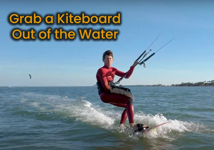 How do I grab a kiteboard out of the water while riding?