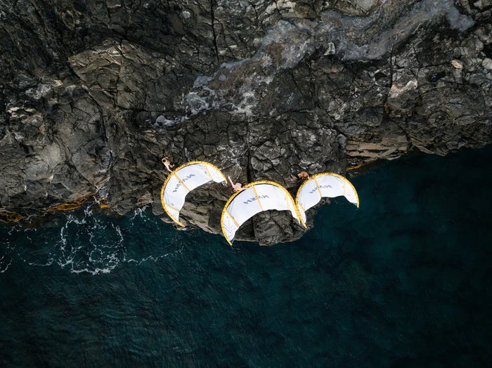 Aerial view of three Naish Pivot Nvision 2026 kites on the cliffs above the ocean in Florida, showcasing the lightweight Aluula frame design tested by Elite Watersports.