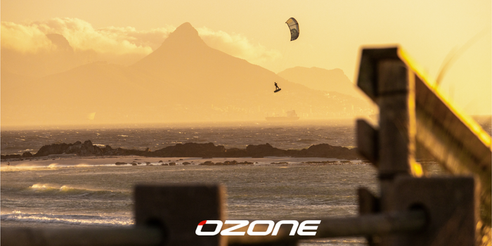 kitesurfer boosting big air with the ozone kite during sunset